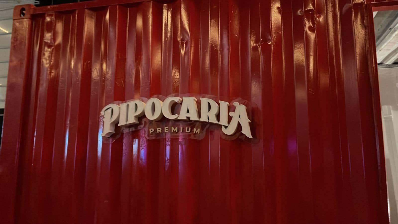 Detalhe do logo Pipocaria Premium em alto relevo na lateral do container