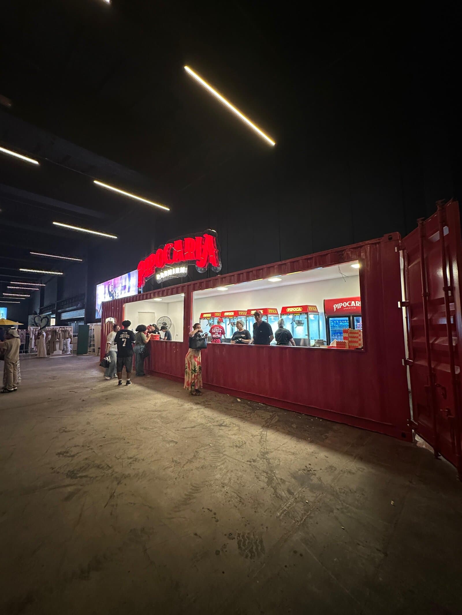 Container Pipocaria Premium à noite atendendo multidão em evento de massa